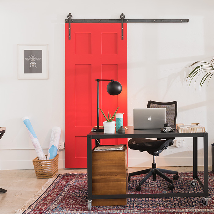 Bright red barn door in a white and modern office.