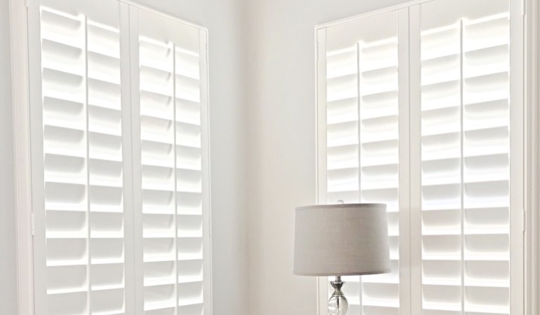 Plantation shutters are available in a multitude of neutral whites and wood stains. Plantation shutters in a corner window.