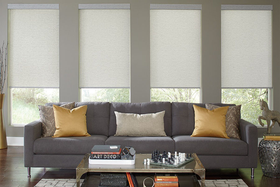 Light gray window shades on a row of windows in a gray living room