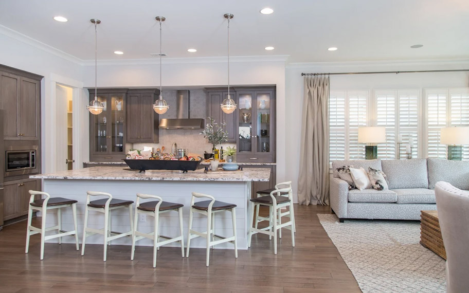 Illuminate your home with custom interior shutters in Houston. White arched shutters in a white kitchen with lots of light.