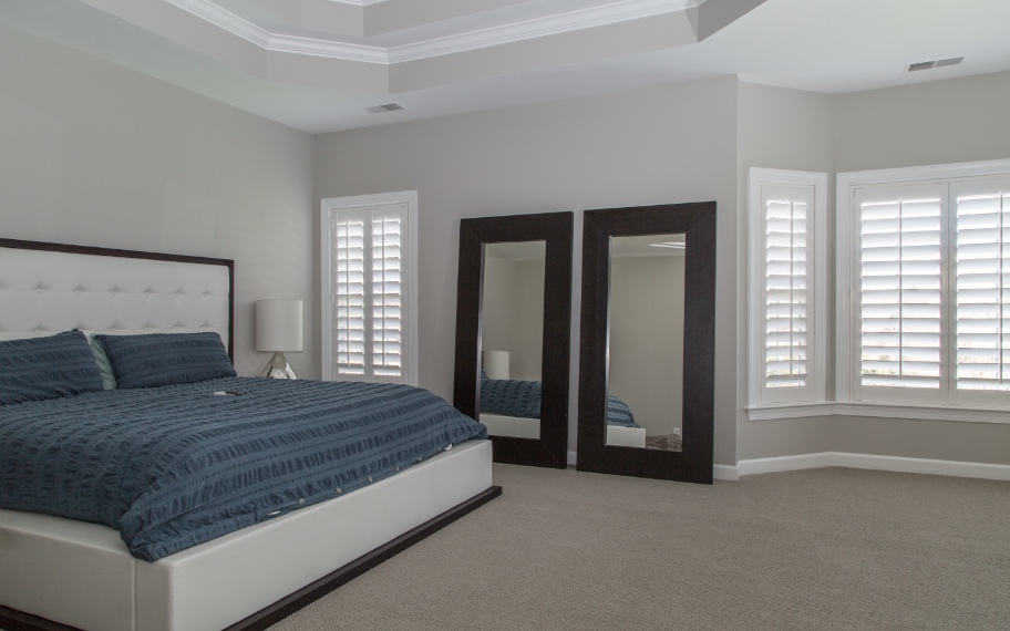 Shutters in a bedroom with a blue bed
