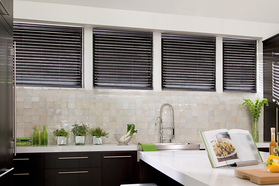 Choose custom Polywood faux wood blinds for your kitchen in Houston. Special shaped faux wood blinds in several windows above a sink.