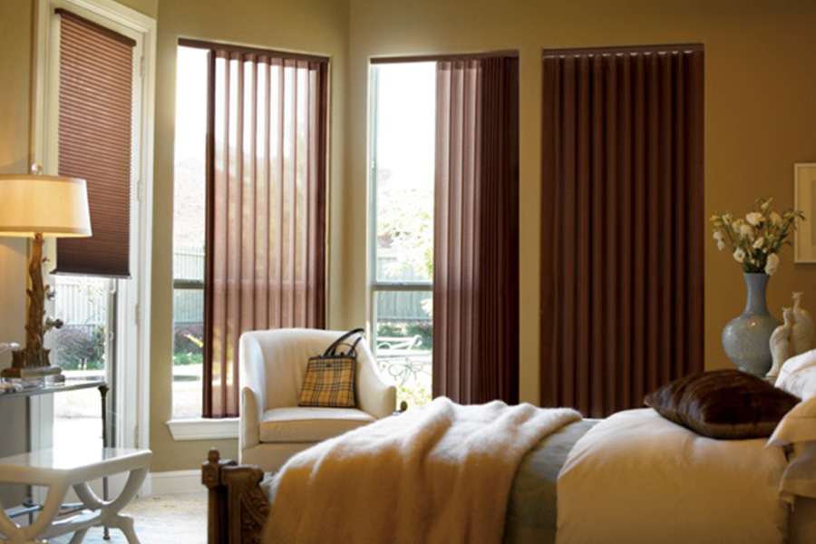 Choose durable and high-quality fabric or vinyl vertical blinds in Houston. Maroon fabric vertical blinds inside a bedroom