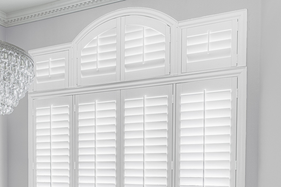 Customize your Palladian windows with white Polywood shutters in Houston. White Polywood Palladian windows in a dining room.