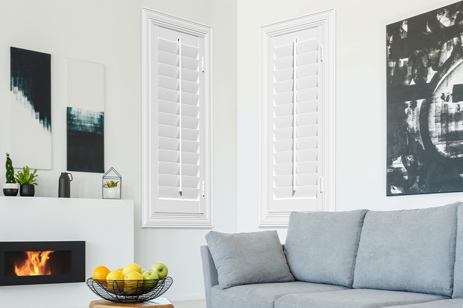 White Polywood shutters add character and class in Houston. White polywood shutters in a corner of a modern living room.