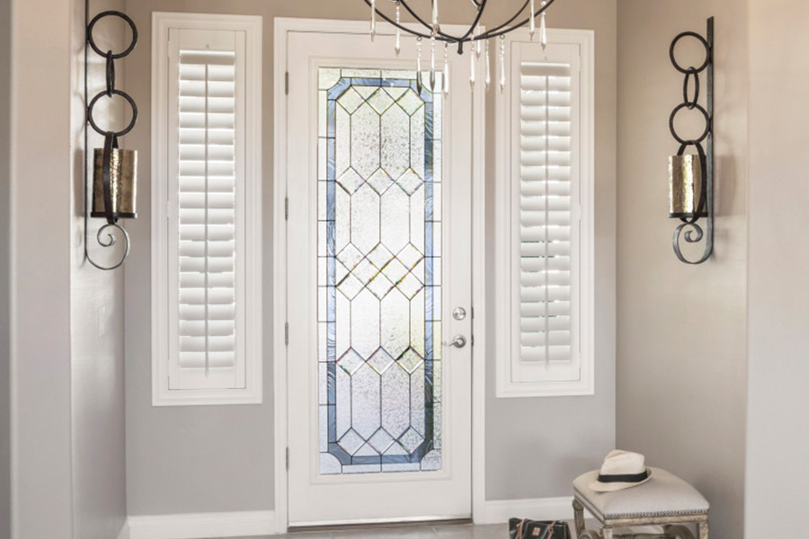 Polywood shutters offer flexibility on the brightness of natural light in Houston. Sidelight windows with white polywood shutters in a foyer.