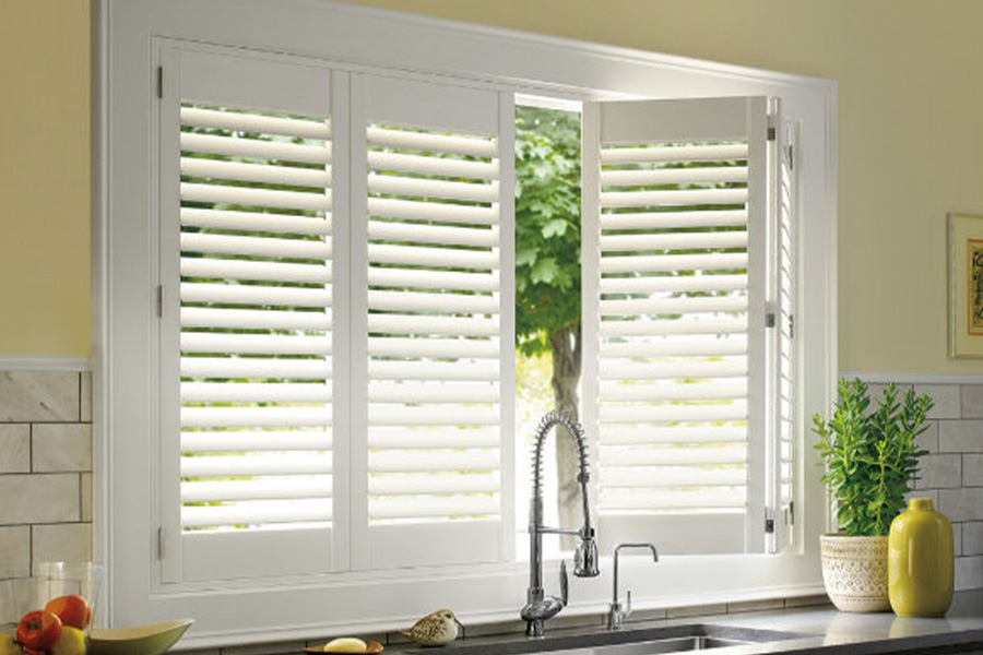 Polywood shutters are built to withstand the test of time in Houston. White Polywood shutters above a kitchen sink.